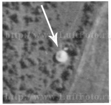 Фанерные палатки, замаскированные/не замаскированные и в процессе строительства/разобранные. Немецкая аэрофотосъемка. Масштаб 1:8000. На снимке показана стрелкой.